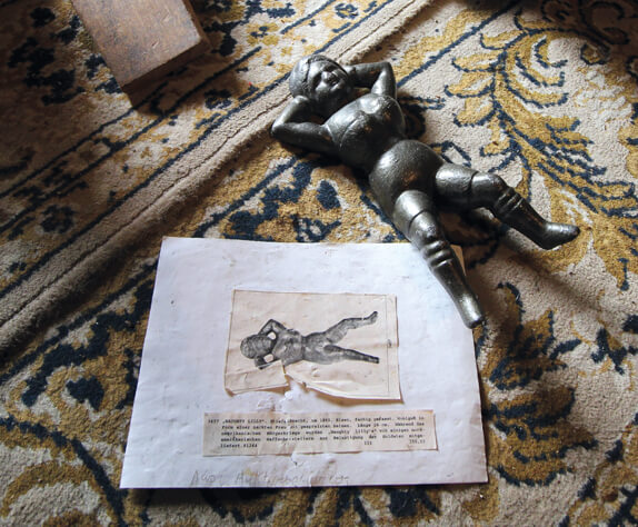 Ein Schriftstück sowie eine Holzfigur von Naughty Lilly ein alter Stiefelknecht